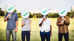 People holding up green tick signs