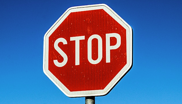 Red and white american style STOP sign against a bright blue sky