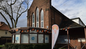 Photograph of Castelnau Community Centre from the street with a banner outside
