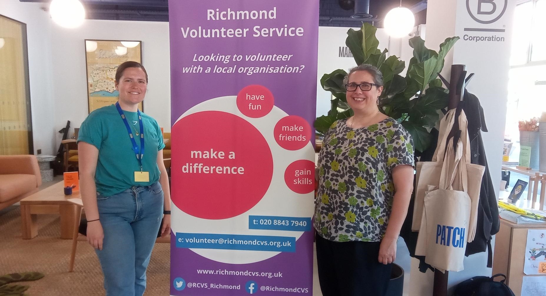 Two women standing either side of stand-up Richmond CVS banner at Patch Twickenham