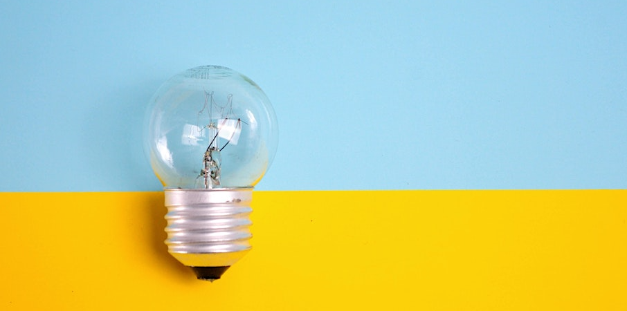 Light bulb in front of a bright blue & yellow background