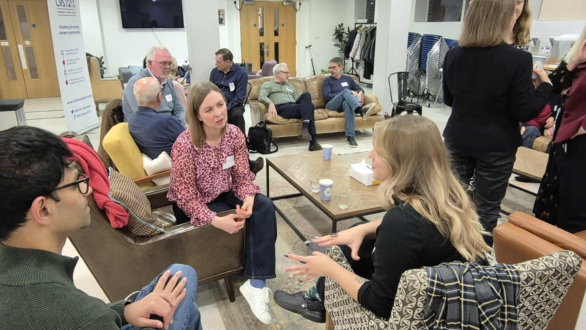 Mixed group of people seated informally and talking at Trustee Forward social event