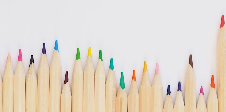 Row of wooden pencils of different lengths and bright colour leads
