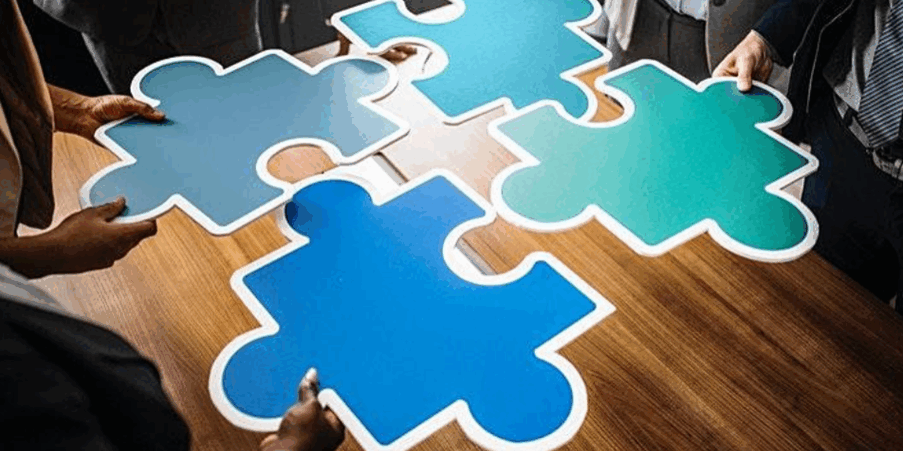 4 large blue jigsaw puzzle pieces on a brown table